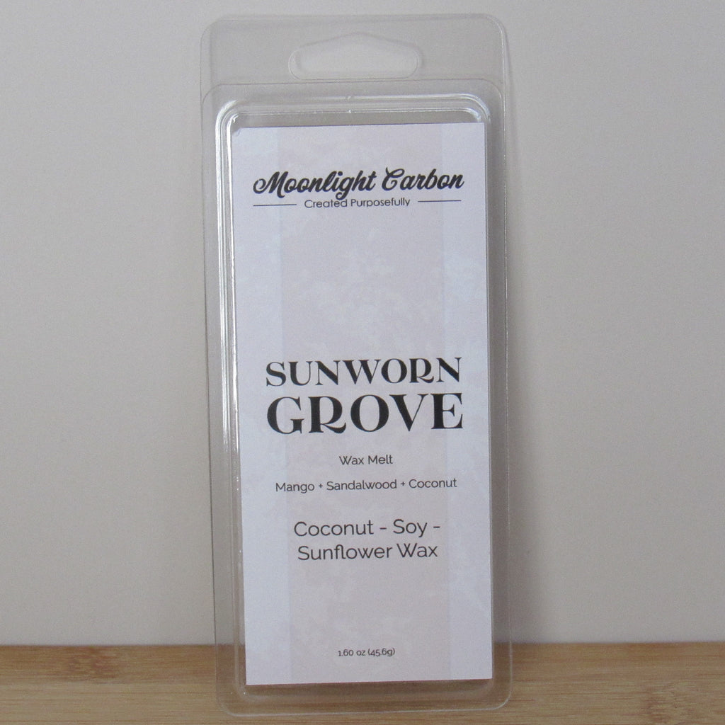 Wax melt package labeled 'Sunworn Grove' by Moonlight Carbon on a plain background. Fragrance notes include mango, sandalwood, and coconut.