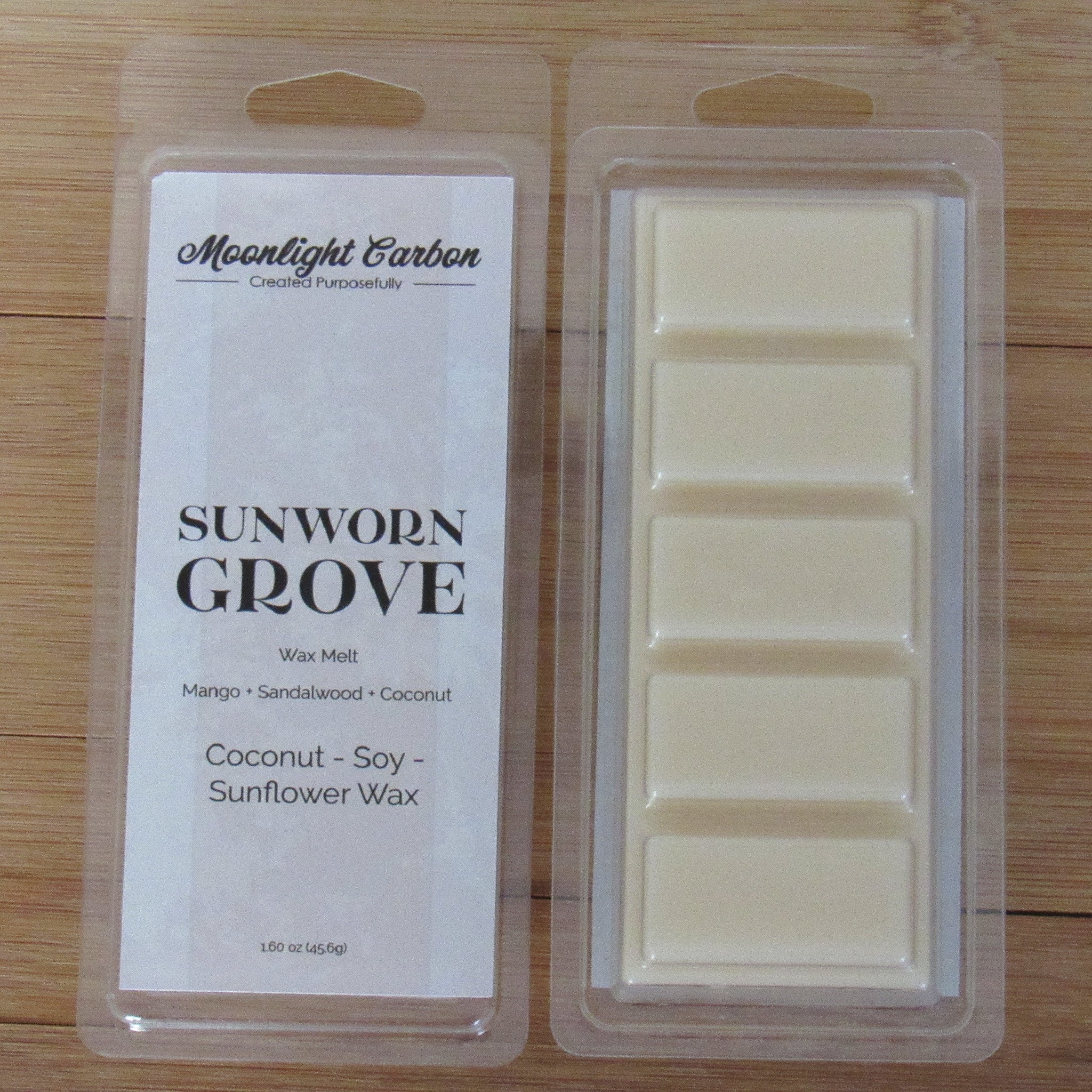 Wax melt packaging with 'Moonlight Carbon' branding on a wooden surface. Shows back of packaging with wax melts divided into 5 parts.