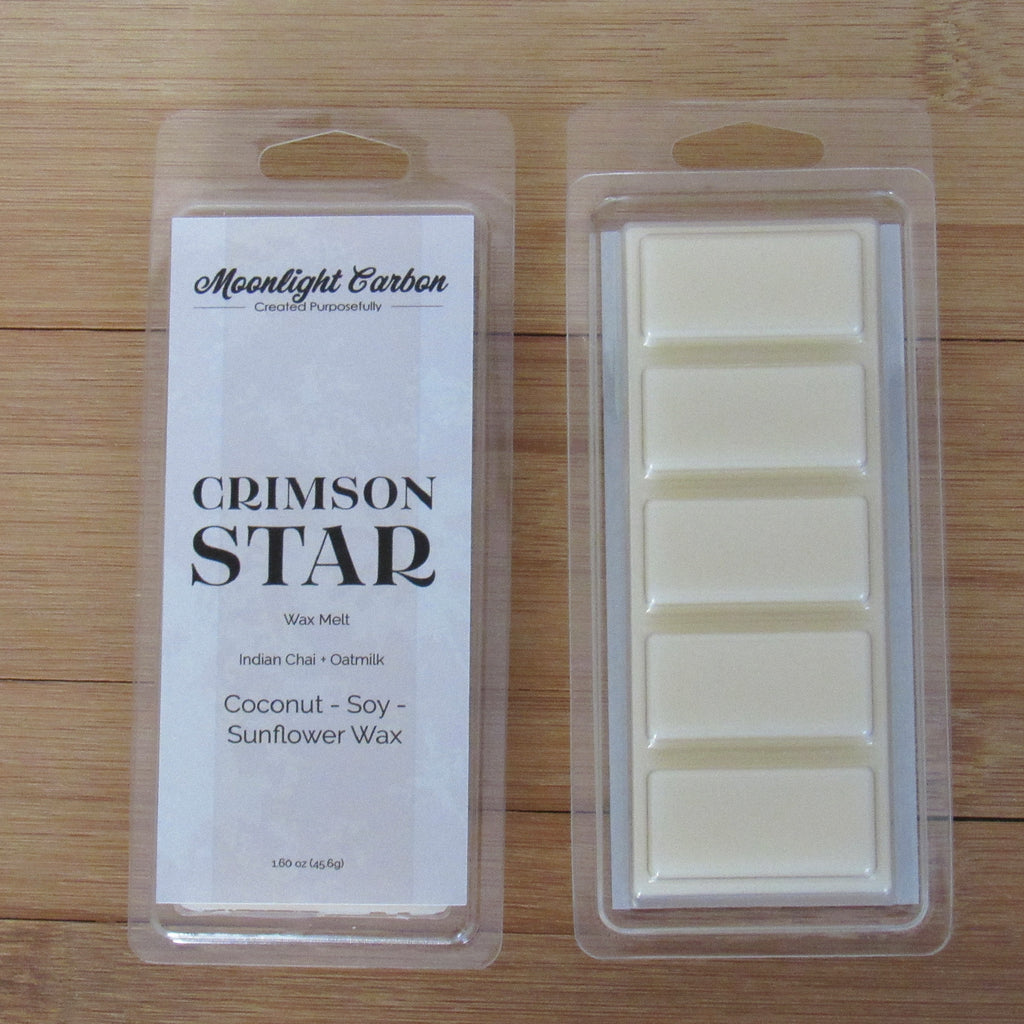 Wax melts in packaging with 'Moonlight Carbon' branding on a wooden surface. Shows back of packaging which displays wax melts able to be broken into 5 pieces.