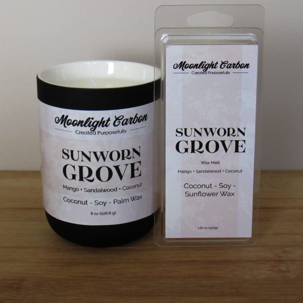 Moonlight Carbon candle and wax melt packaging labeled "Sunworn Grove" on a wooden surface
