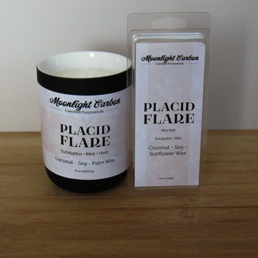 Candle labeled 'Placid Flare' by Moonlight Carbon next to its wax melt packaging on a wooden surface.