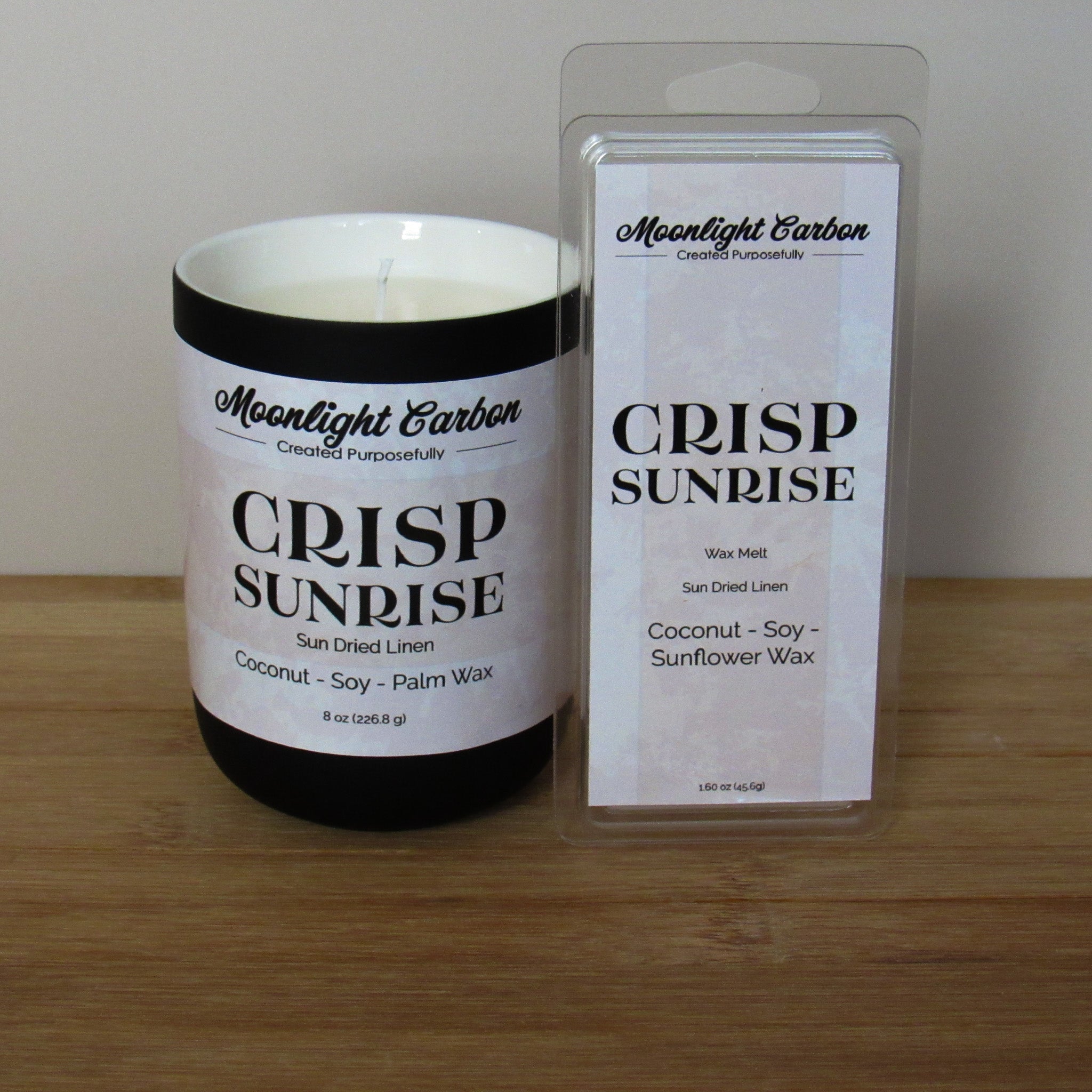 Candle and wax melt packaging of 'Crisp Sunrise' scented wax melts by Moonlight Carbon on a wooden surface.